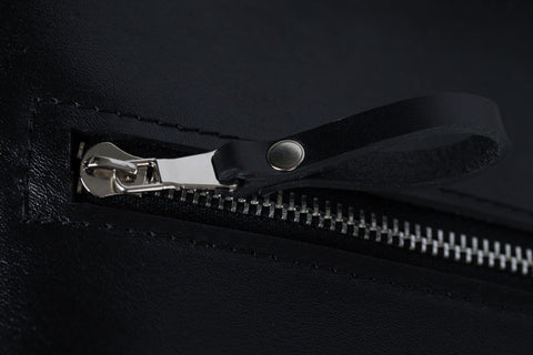 5. Close-up of PYKOK Serenity handbag's front zipper and leather pull tab
