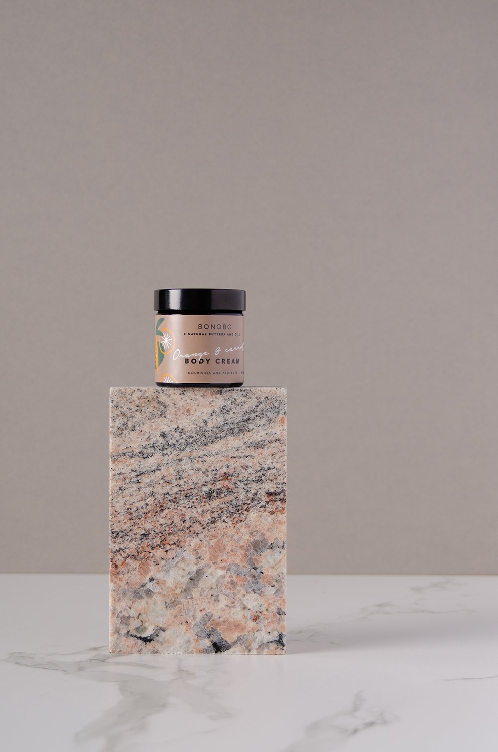 3. BONOBO Orange & Carrot Body Cream jar displayed on a marble block, highlighting elegant packaging