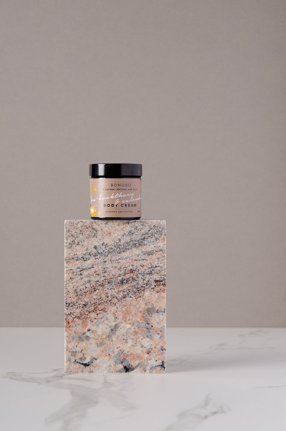 3. BONOBO Sea-Buckthorn and Calendula Body Cream jar displayed on stone pedestal in studio setting