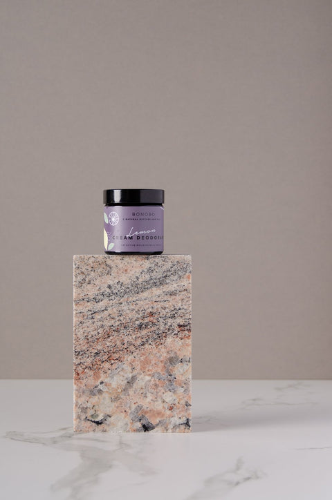 1. BONOBO Lemon Deodorant-Cream jar displayed on a marble block in a studio setting