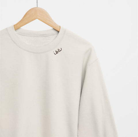 3. Beige organic cotton sweatshirt with 'Isä' embroidery on hanger in studio setting