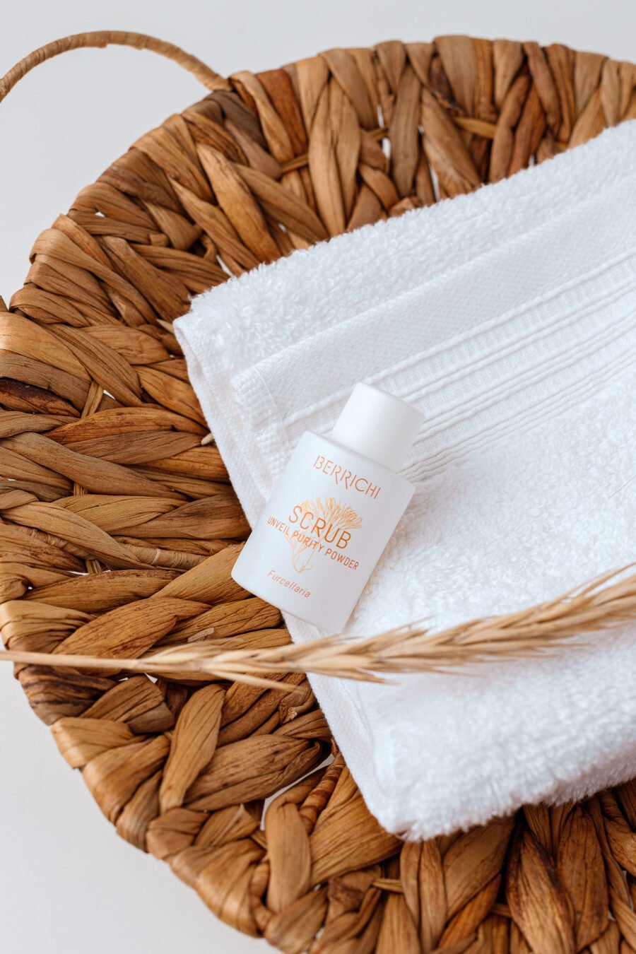 1. Berrichi Reveal Purity Powder SCRUB, 12g, displayed on a woven basket with a white towel, highlighting natural skincare setting