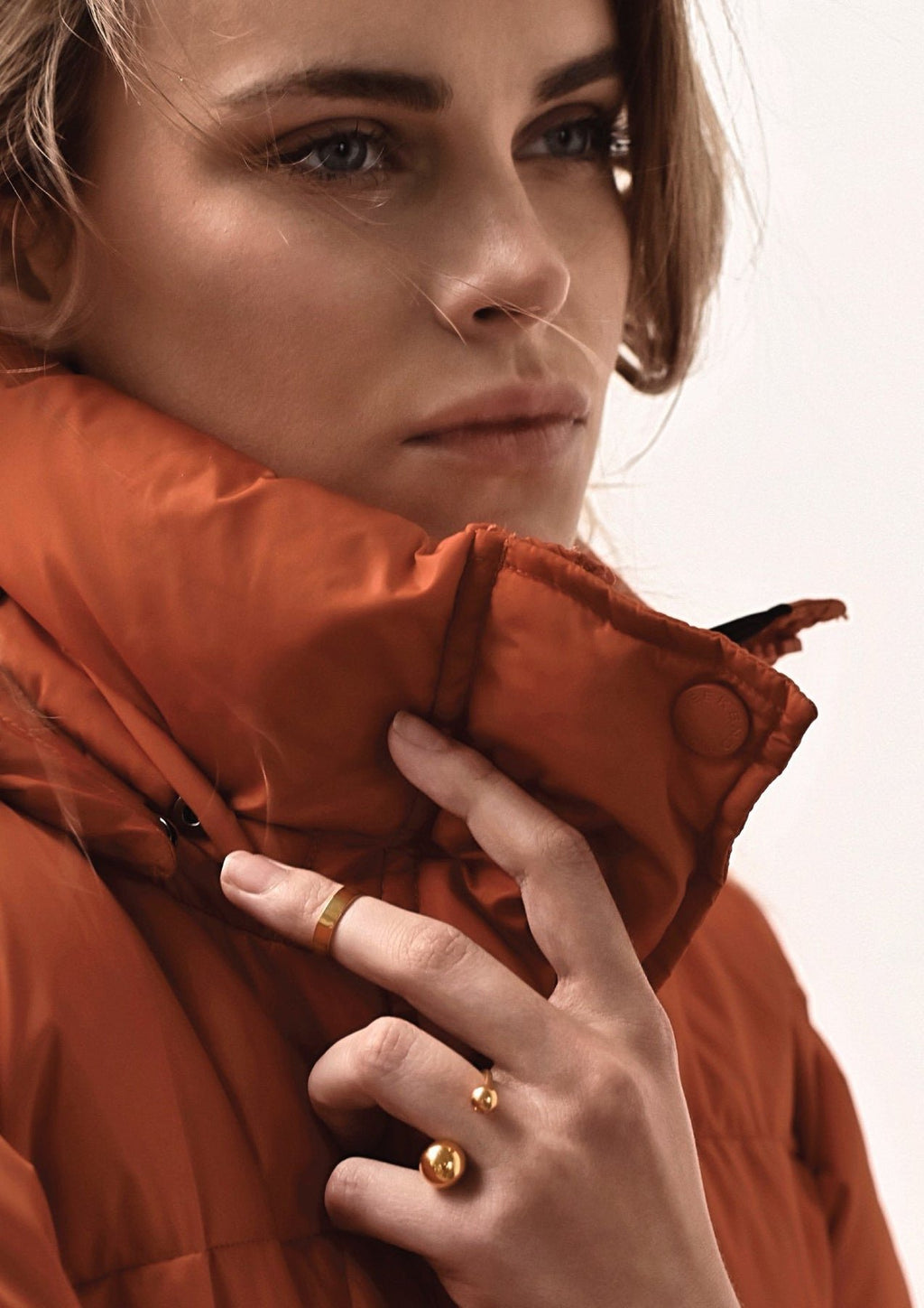 2. Woman wearing NO MORE Big Bomb Multisize Ring in gold, styled with an orange jacket, highlighting bold bubble design