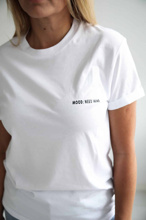 2. Close-up of women's white 'Mood: Need Wine' T-shirt by Black Giraffe Brand, featuring rolled-up sleeves and text detail