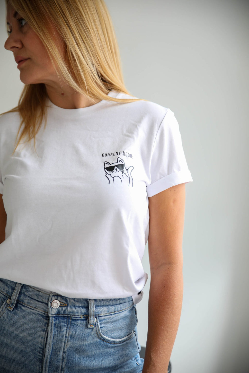 1. Women's white Current Mood T-Shirt with kitty design by Black Giraffe Brand, worn by model in casual setting