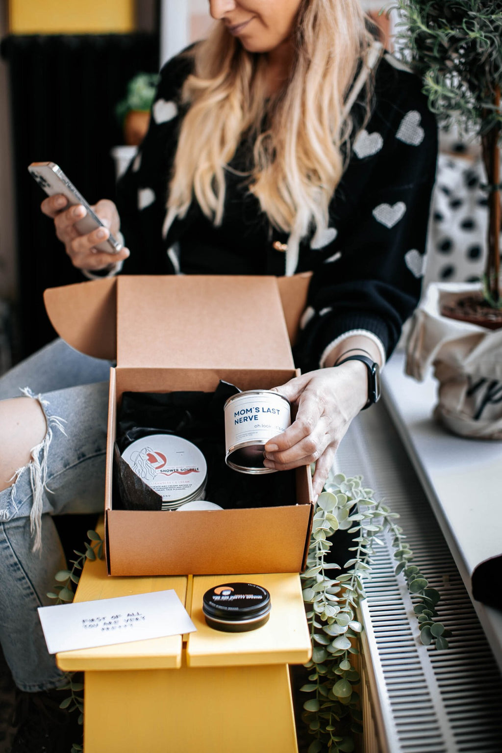4. Woman showcasing Black Giraffe Body Care Gift Set, highlighting 'Mom's Last Nerve' candle