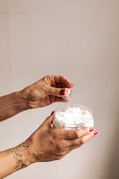 2. Close-up of Black Giraffe Brand Exfoliating Shower Cream texture being scooped from jar