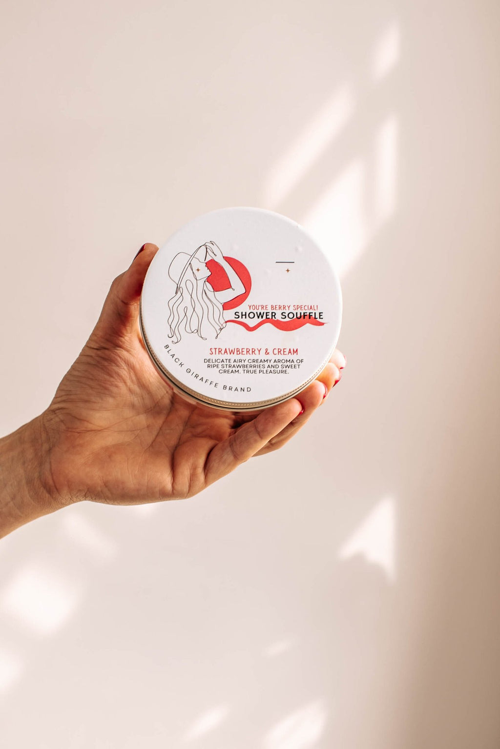 3. Black Giraffe Brand Exfoliating Shower Cream held in hand, highlighting Strawberry & Cream scent