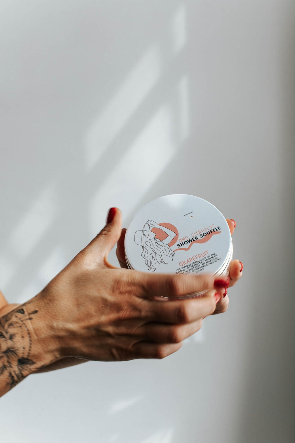 1. Black Giraffe Brand Exfoliating Shower Cream in hand, showcasing Strawberry & Cream scent packaging