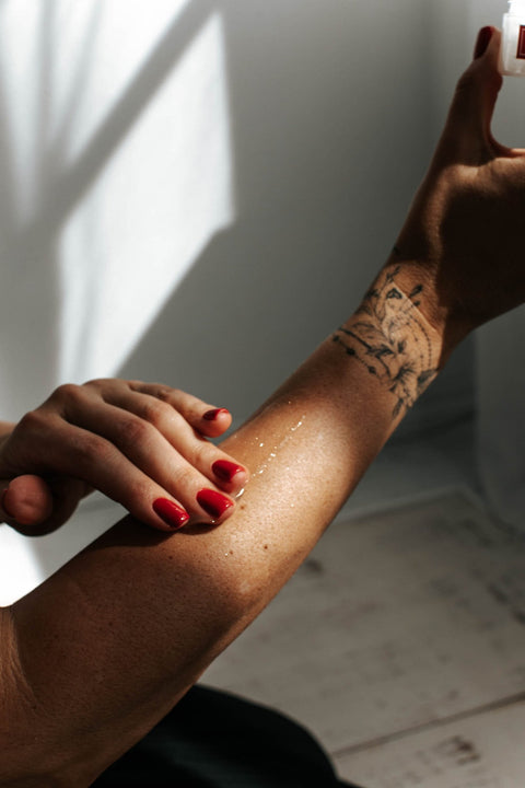 1. Woman applying Black Giraffe Brand Sparkling Body Gel on arm, showcasing shimmer effect