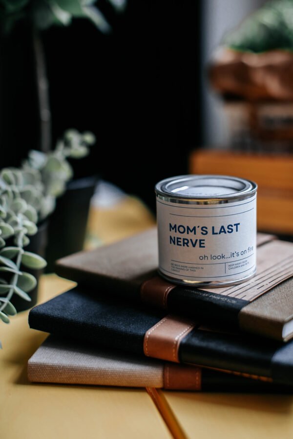 8. 'Mom's Last Nerve' soy wax candle from Black Giraffe Body Care Gift Set, styled on books
