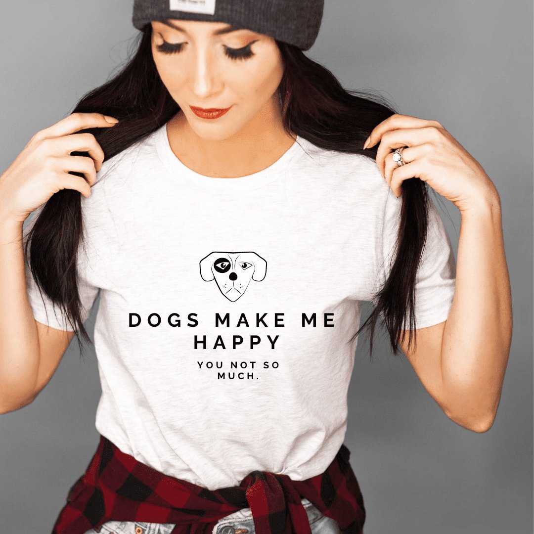 1. Woman wearing white Black Giraffe Brand 'Dogs Make Me Happy' T-shirt with rolled-up sleeves, styled with a beanie and plaid shirt, in a casual setting