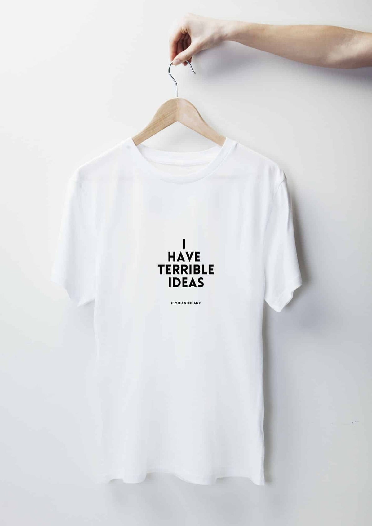 3. White 'I Have Terrible Ideas' t-shirt by Black Giraffe Brand, displayed on hanger in studio setting