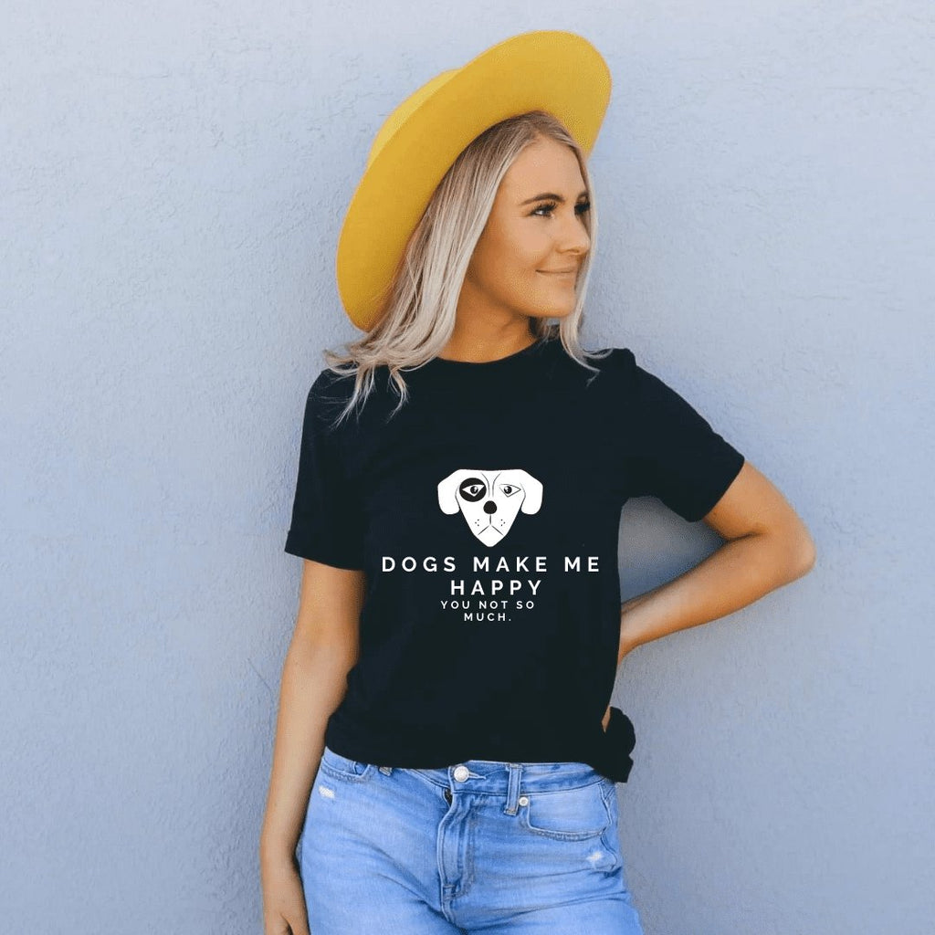 2. Woman in black Black Giraffe Brand 'Dogs Make Me Happy' T-shirt with rolled-up sleeves, paired with a yellow hat and jeans, standing against a wall