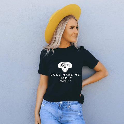 2. Woman in black Black Giraffe Brand 'Dogs Make Me Happy' T-shirt with rolled-up sleeves, paired with a yellow hat and jeans, standing against a wall
