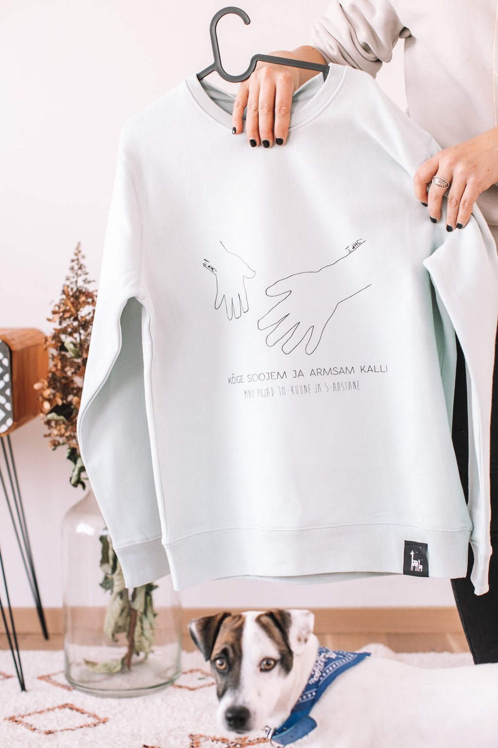 6. Sage green sweatshirt with hand-drawn artwork, Black Giraffe Brand, shown in lifestyle setting with dog