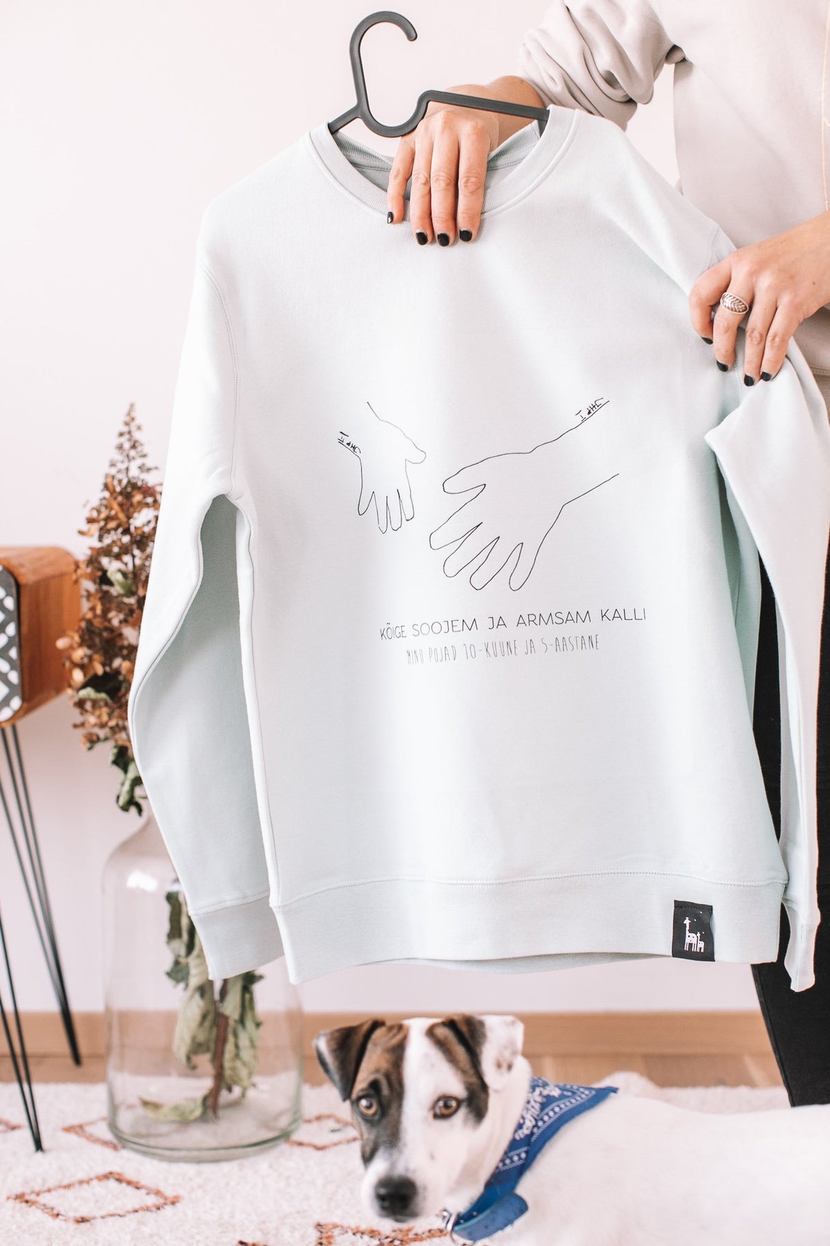 6. Sage green sweatshirt with hand-drawn artwork, Black Giraffe Brand, shown in lifestyle setting with dog