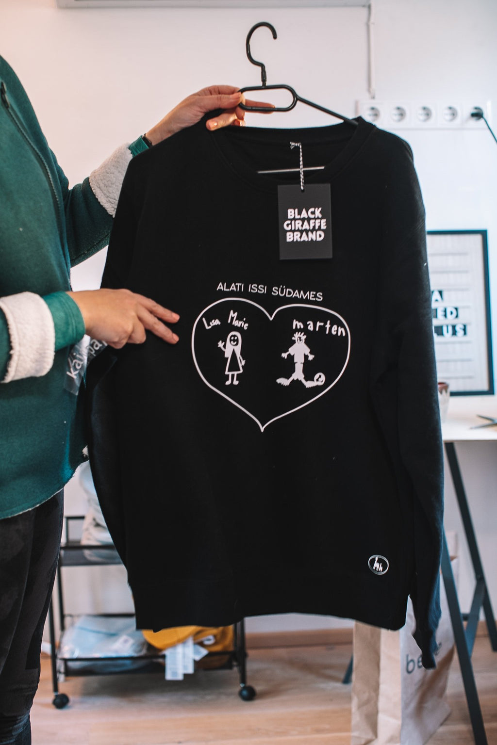 2. Black sweatshirt with personalized child's drawing, Black Giraffe Brand, displayed in studio