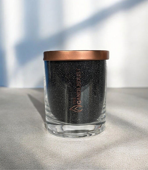 2. Black unscented powder candle by Candledust with metal lid, displayed in glass container