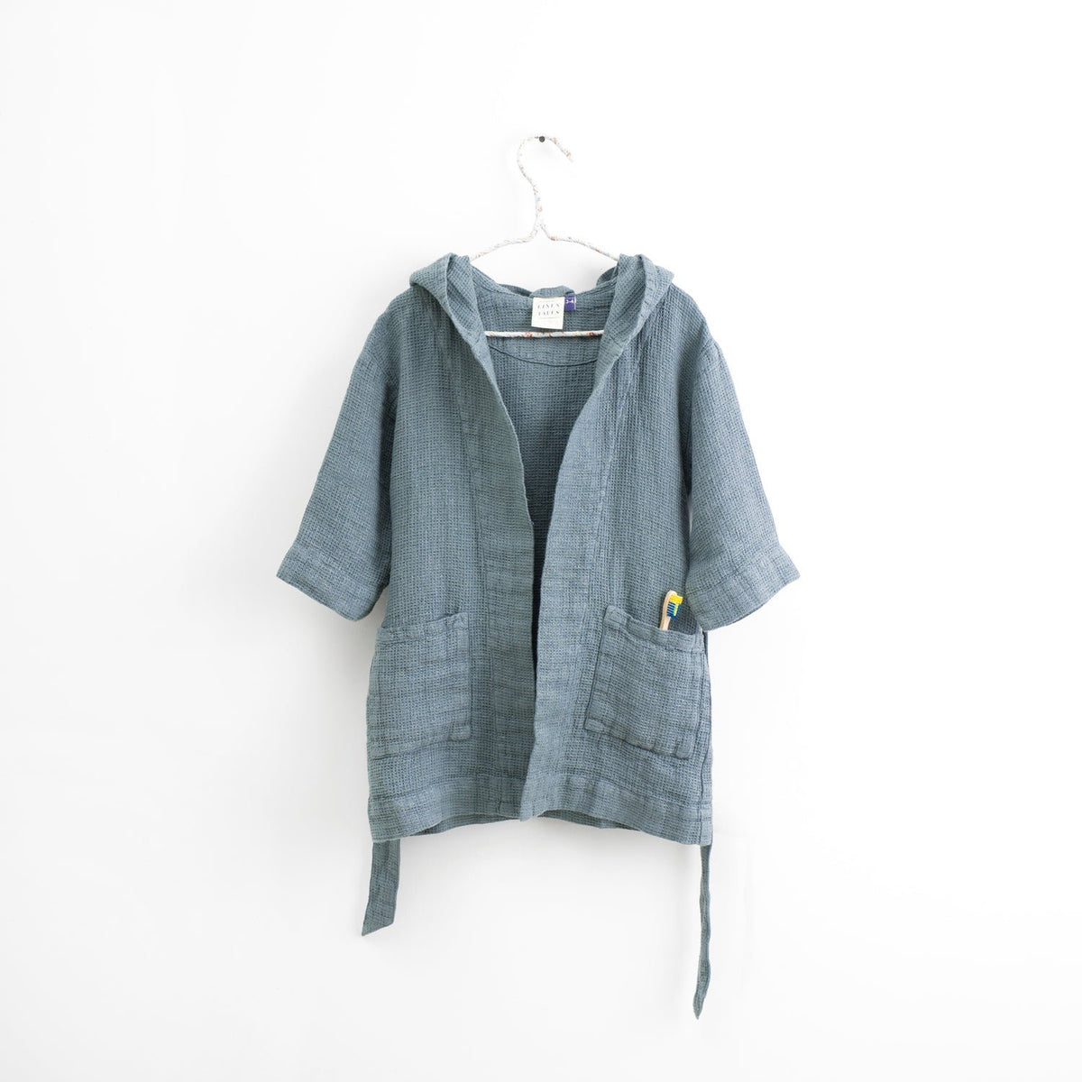 2. Kids' blue fog linen bathrobe with hood hanging on white background