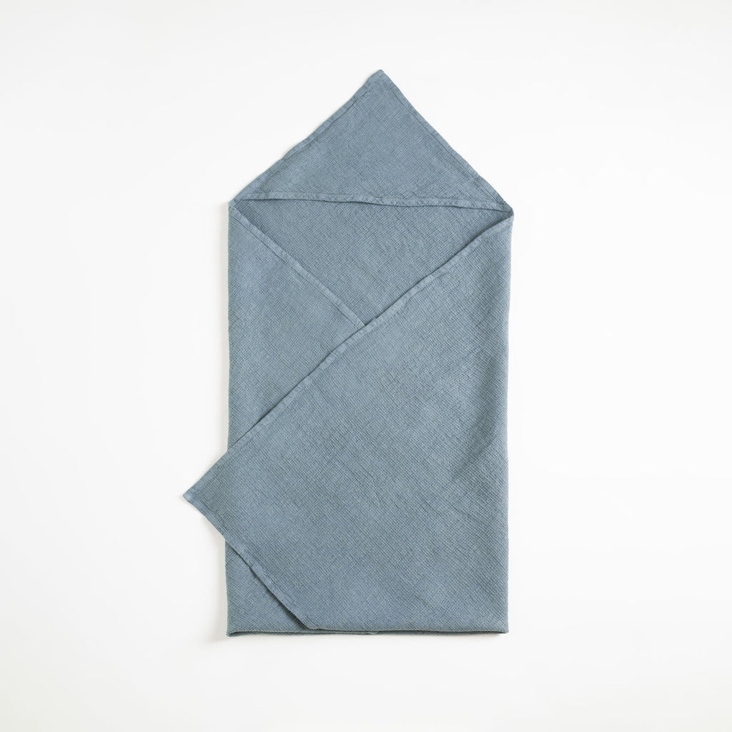 3. Blue fog linen hooded towel laid flat on a white background
