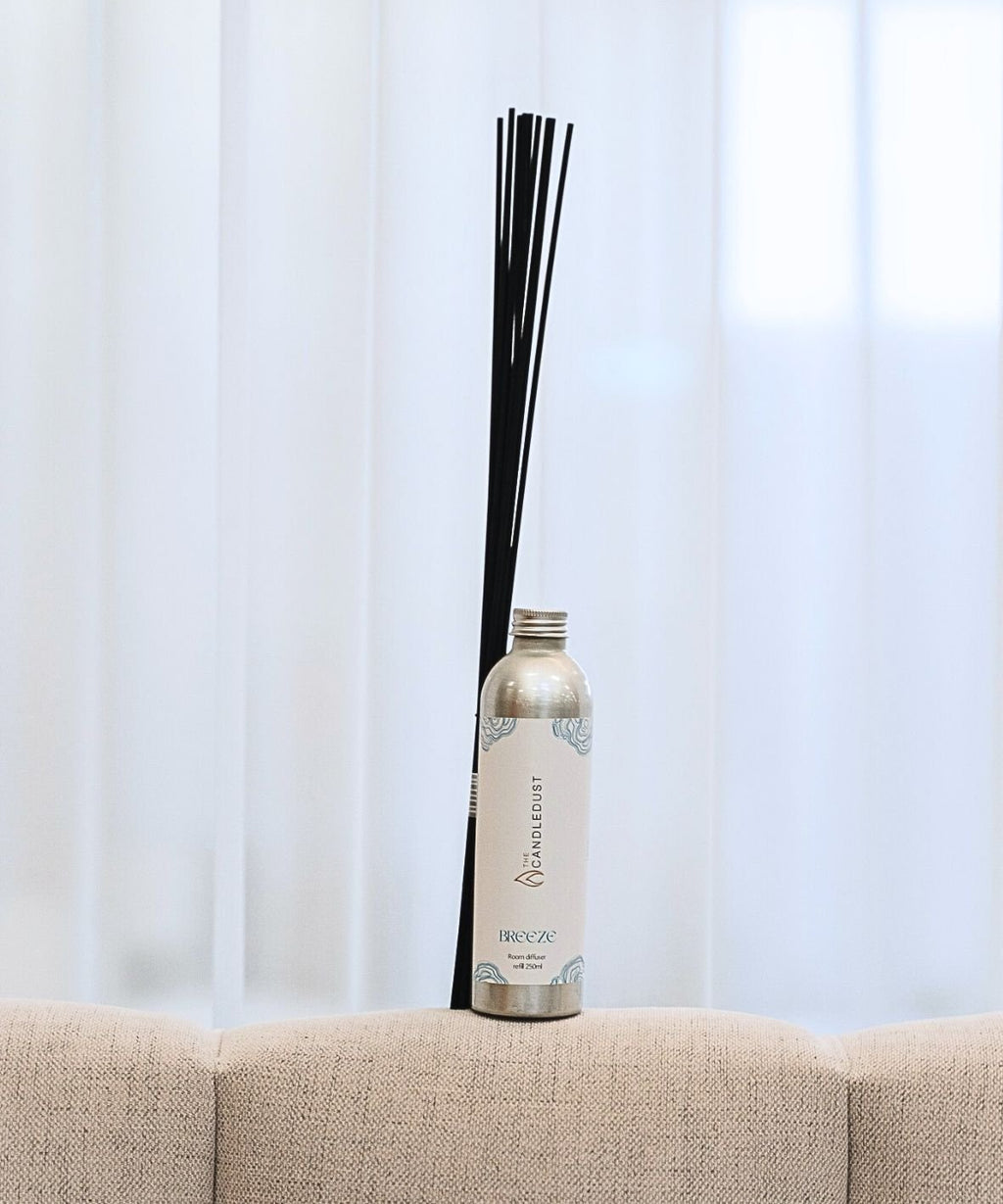 1. Candledust Breeze room diffuser refill with black fiber sticks on a beige sofa