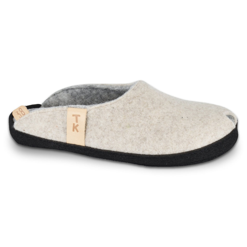1. TOKU Brussels natural white slippers in studio, showcasing black microfibre sole and lambswool felt upper