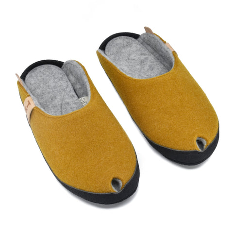 2. Studio image of TOKU Brussels slippers in mustard yellow, showing top view with black microfibre sole and lambswool felt upper