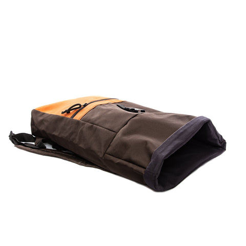 3. Side view of Drinbags CAKE waterproof backpack in brown and orange, highlighting compact design