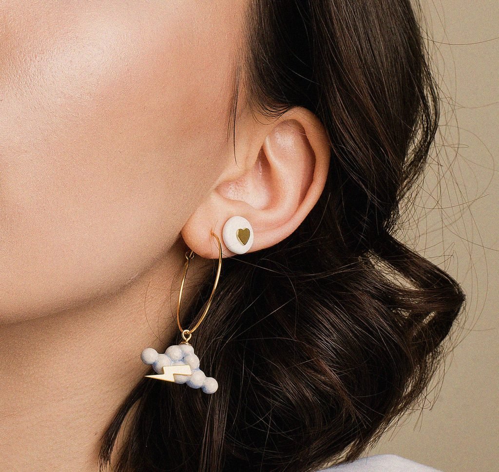 1. Woman wearing SCULP Eye in the Sky earrings with handcrafted ceramic and 24K gold details, shown in lifestyle setting