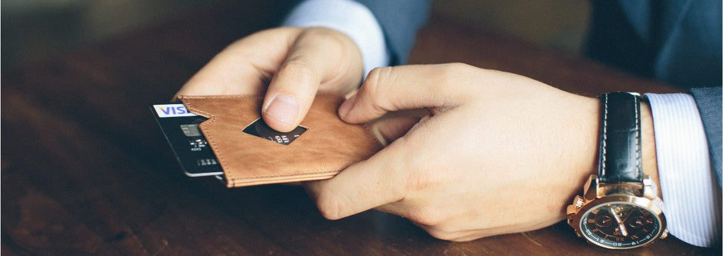 17. Person holding EXENTRI City sand cardholder with RFID feature in formal setting