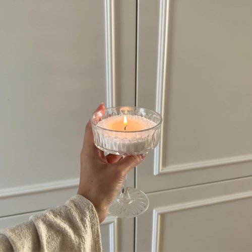 6. Hand holding a lit Candledust powder candle in an elegant glass holder