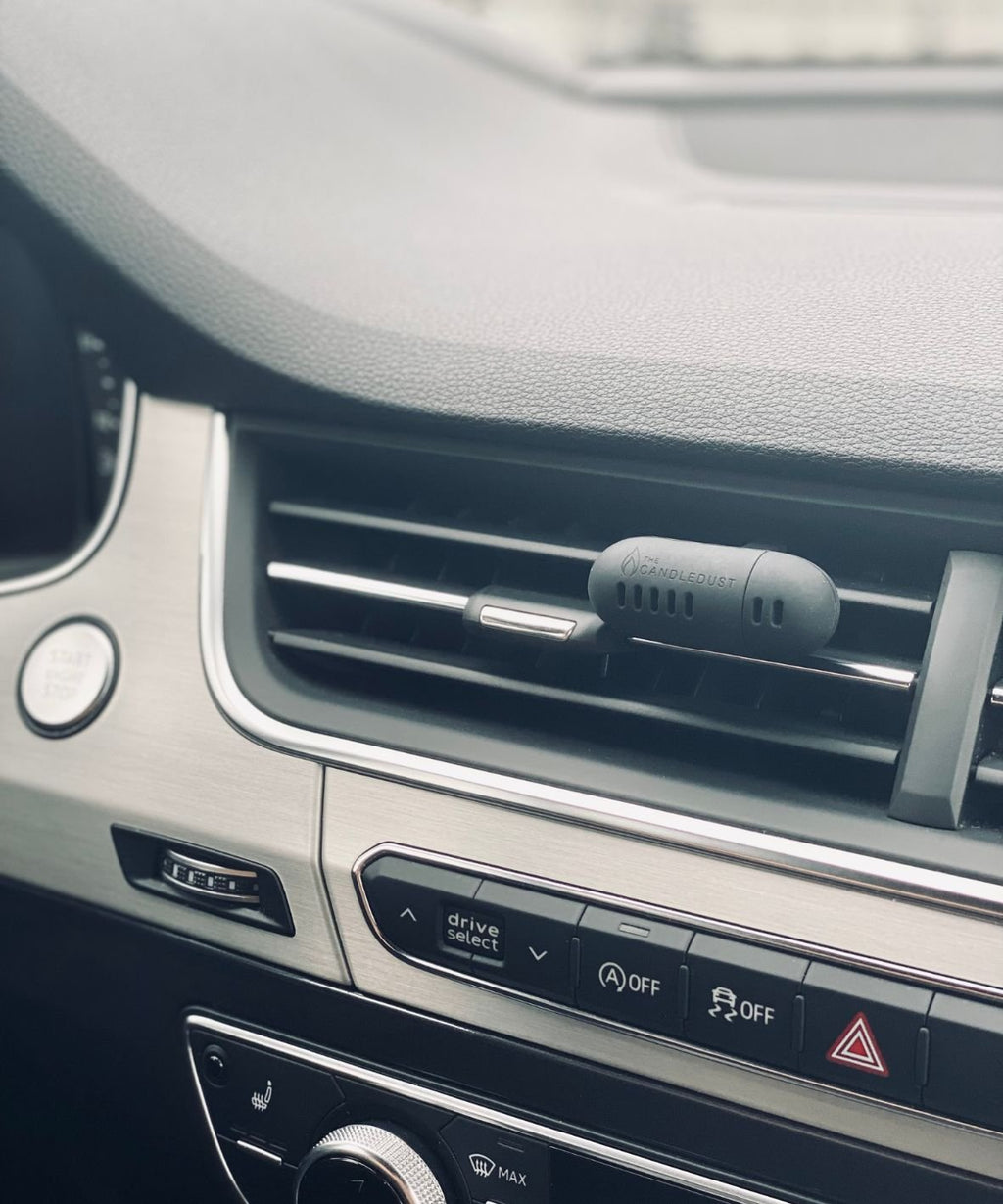 1. Candledust Breeze car diffuser attached to vehicle air vent, showcasing sleek design