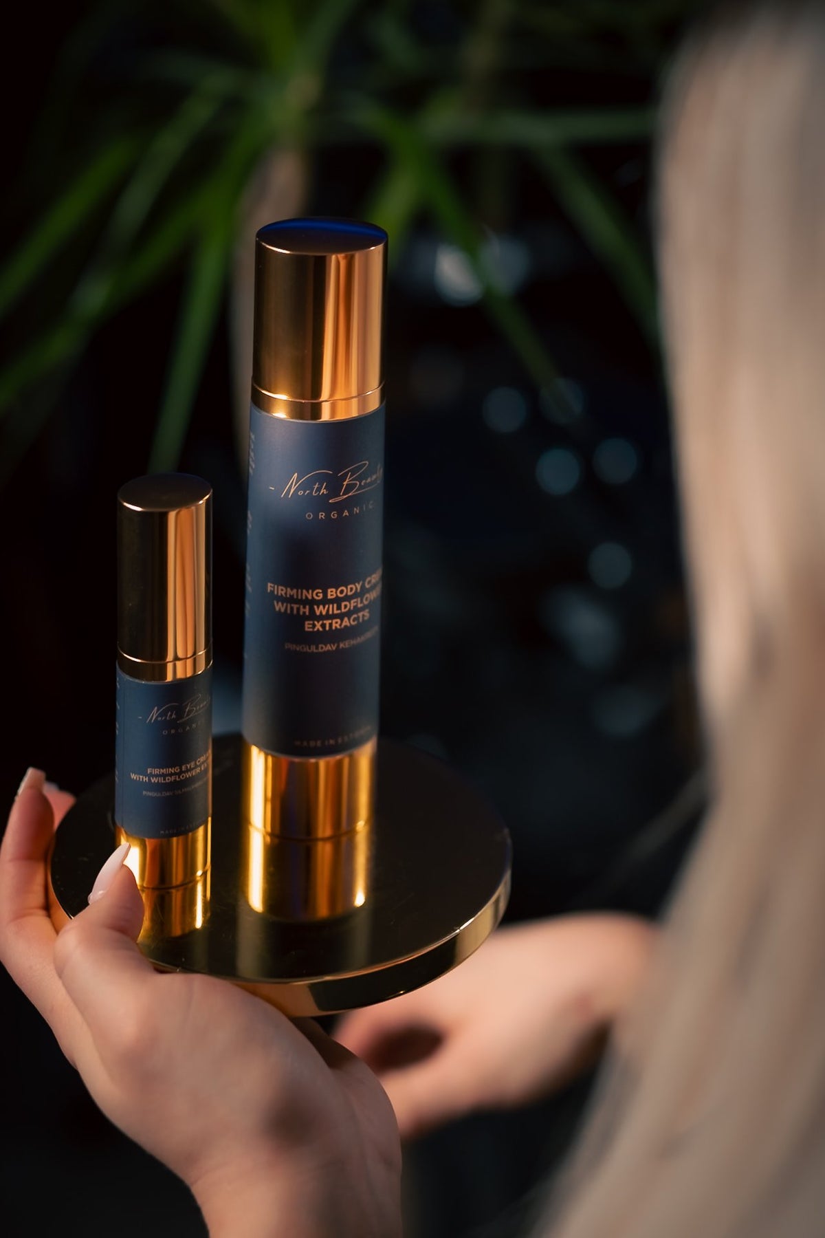 1. North Beauty firming eye cream and body cream held by a woman, showcasing luxurious packaging in a lifestyle setting