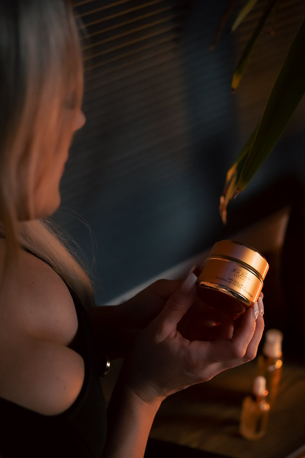 1. Woman holding North Beauty 24K Gold Restoring and Nourishing Face Cream in lifestyle setting