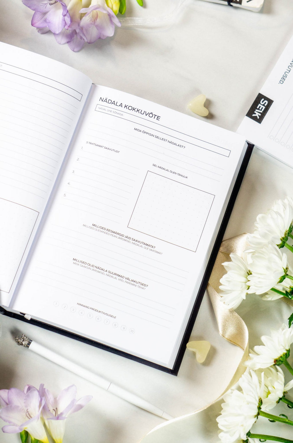 1. Open Get (sh)it done #Produktiivsuspäevik planner with daily productivity pages, surrounded by flowers