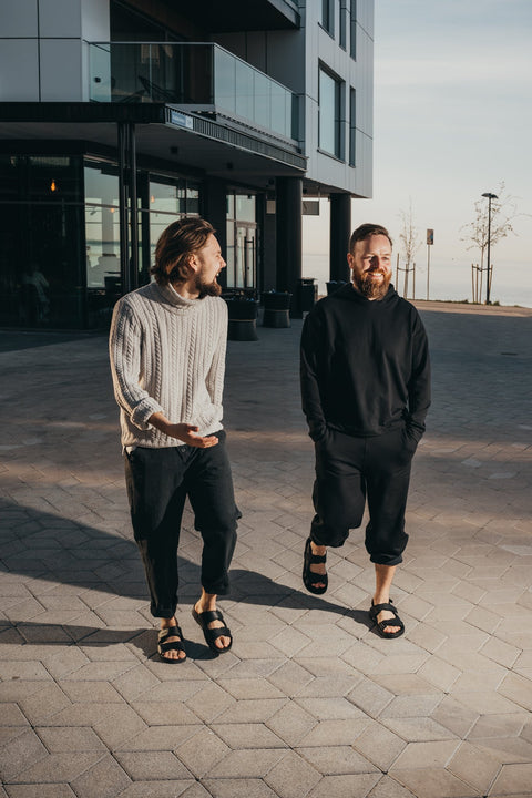 3. Two men walking in urban setting wearing Omaking Lauri Leather Sandals in black, emphasizing casual style