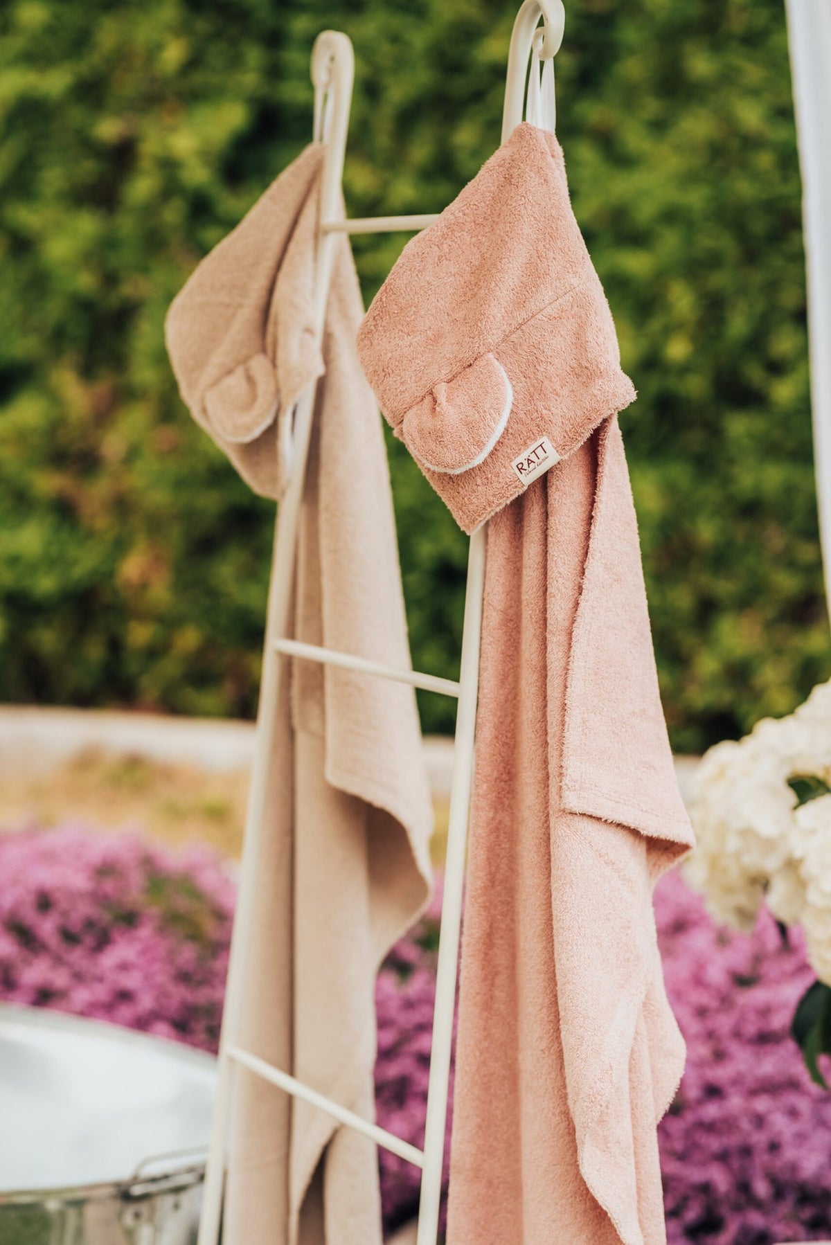 3. RÄTT Hooded Baby Bath Towels TEDDY in beige and pink hanging on rack, outdoor setting