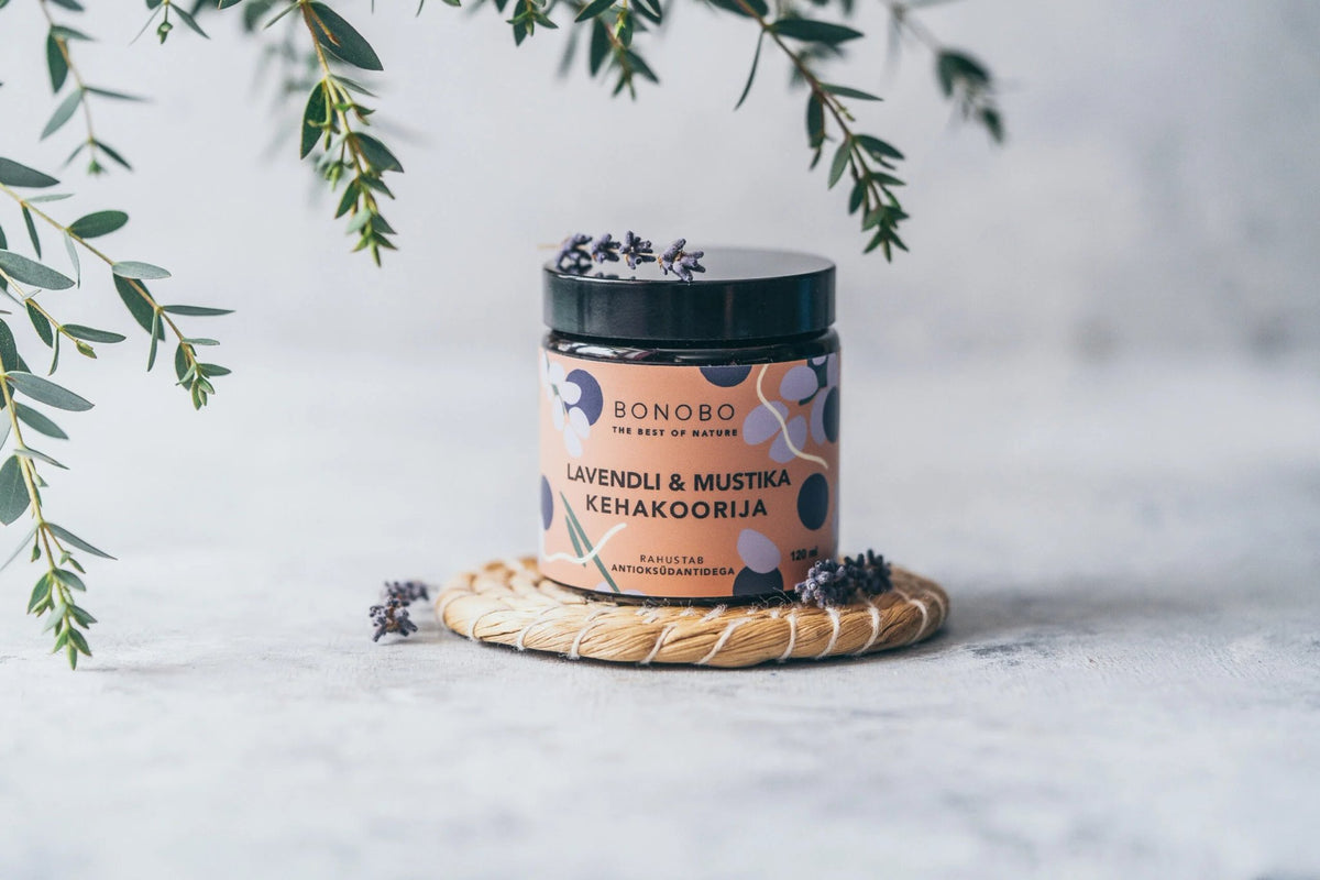 1. BONOBO Blueberry and Lavender Body Scrub jar on a woven mat with lavender sprigs, lifestyle setting