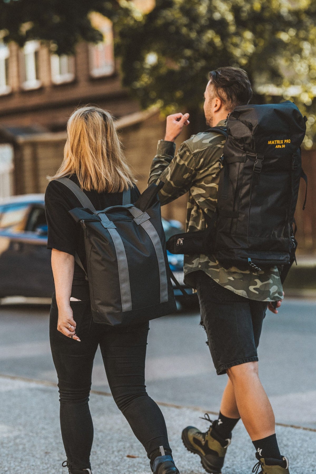 2. Man and woman walking with Matrix Pro Alfa 30 hiking bag in urban environment