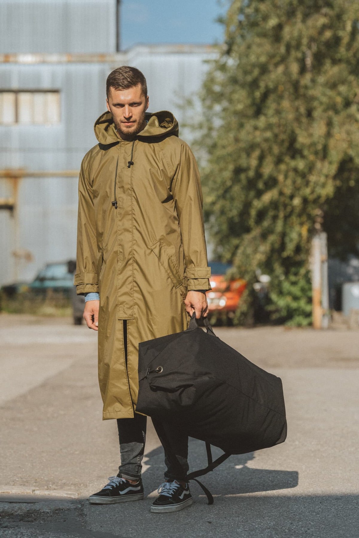 2. Man holding black Galvi Linda Duffle Bag 047 by handle, outdoor setting