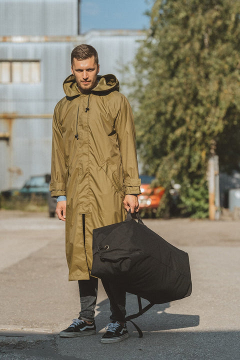 2. Man holding black Galvi Linda Duffle Bag 047 by handle, outdoor setting