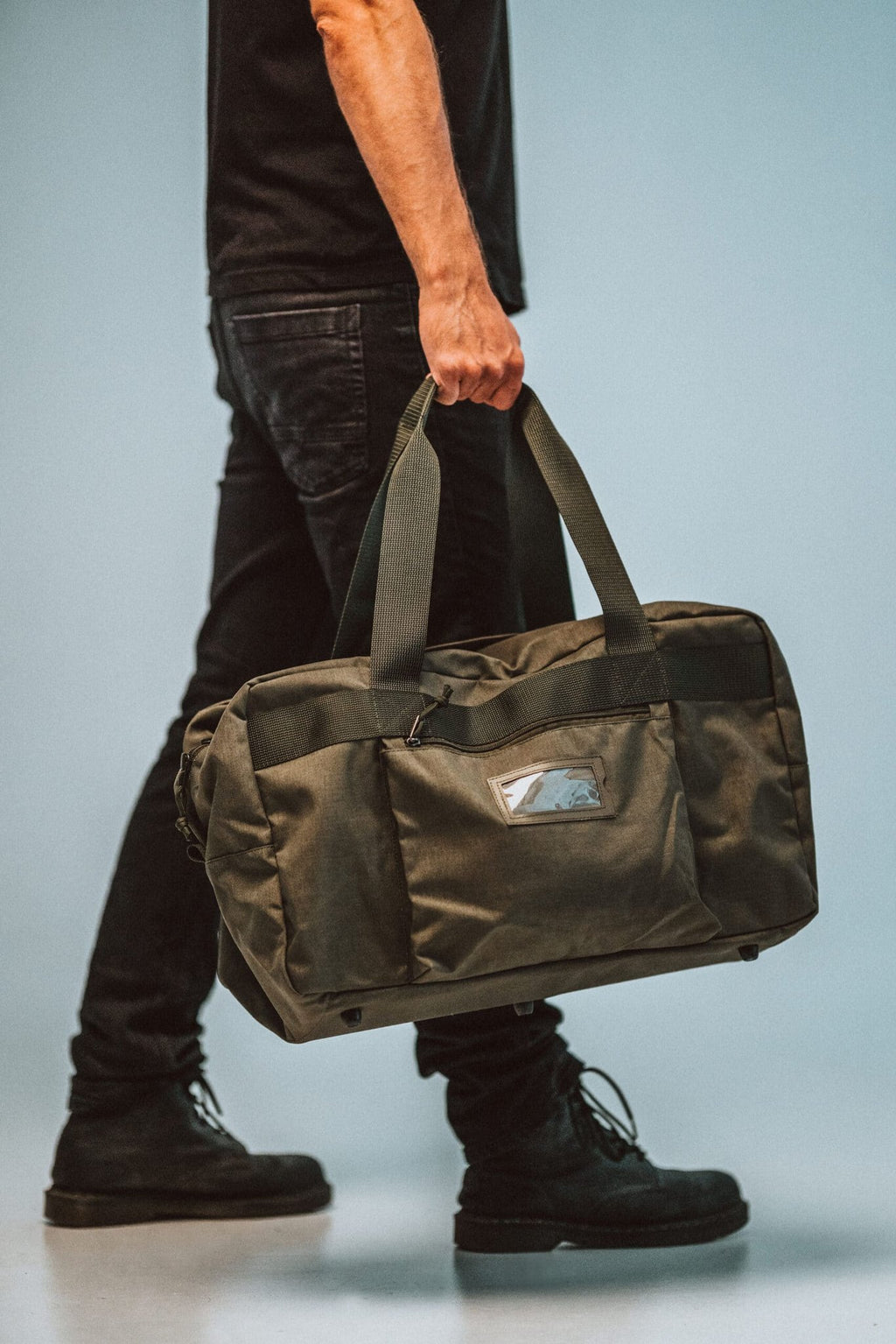 1. Man carrying Galvi Linda Travel Bag 008 in military green, showcasing versatile use and design