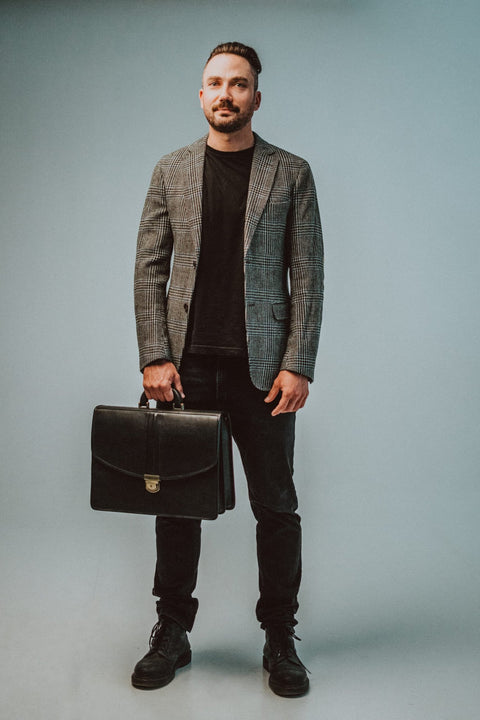 1. Men's black leather briefcase by Papillon, styled with a plaid blazer in a lifestyle setting
