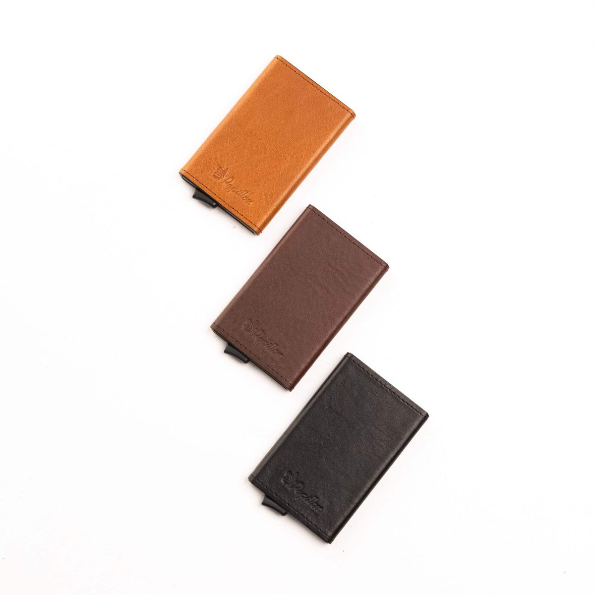 2. Trio of Papillon Card Holder No. 40 in cognac, brown, and black leather, displayed in studio setting