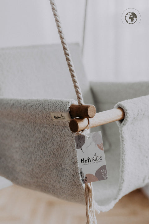 3. Close-up of Nofi KIDS bouclé ice grey swing showing oak wood poles and brand tag