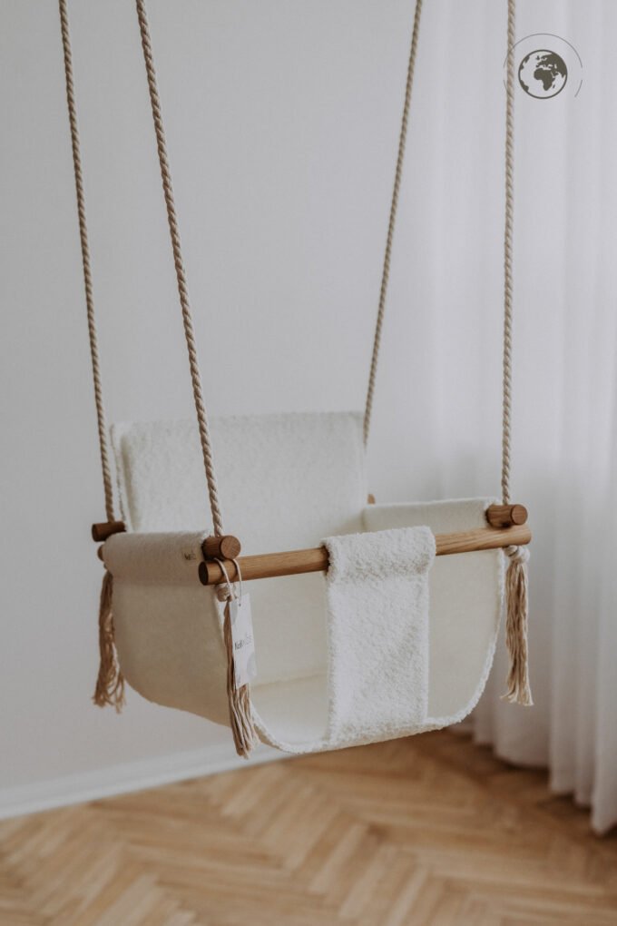 1. Bouclé snow white baby swing with oak wood poles hanging in a bright room