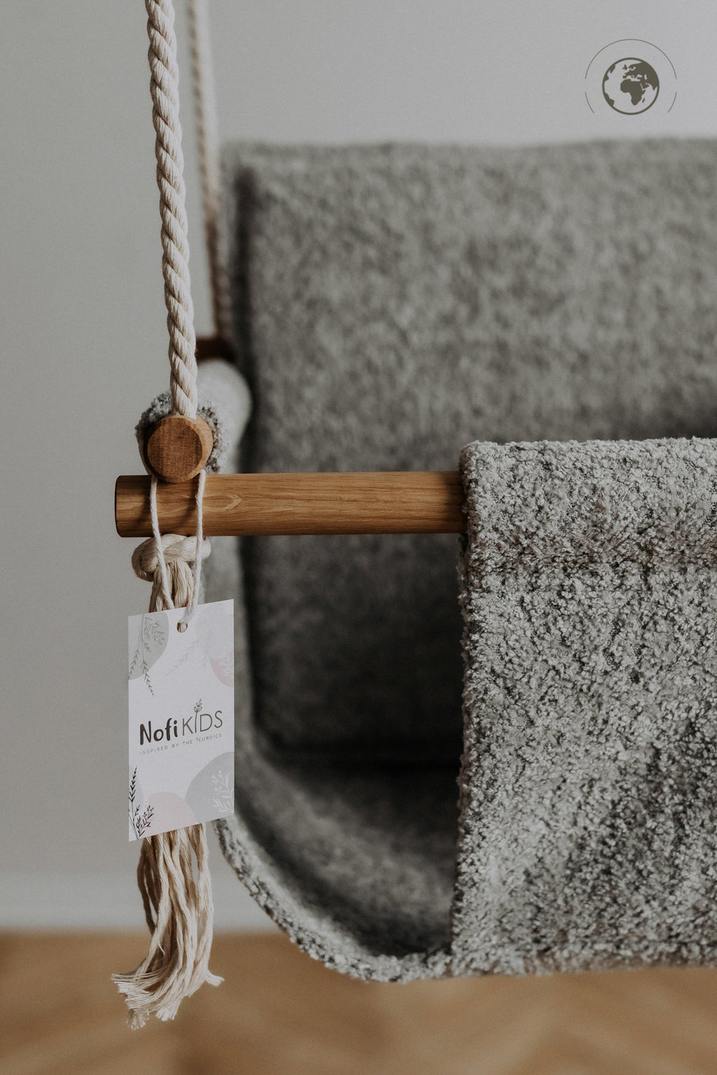 3. Close-up of Nofi KIDS tag on bouclé stone grey fabric of baby swing