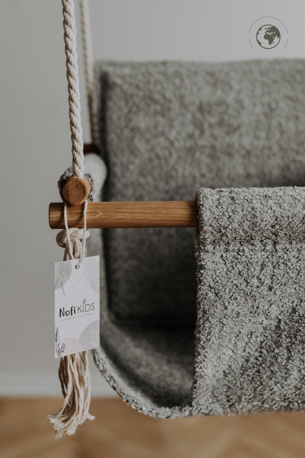 3. Close-up of Nofi KIDS tag on bouclé stone grey fabric of baby swing