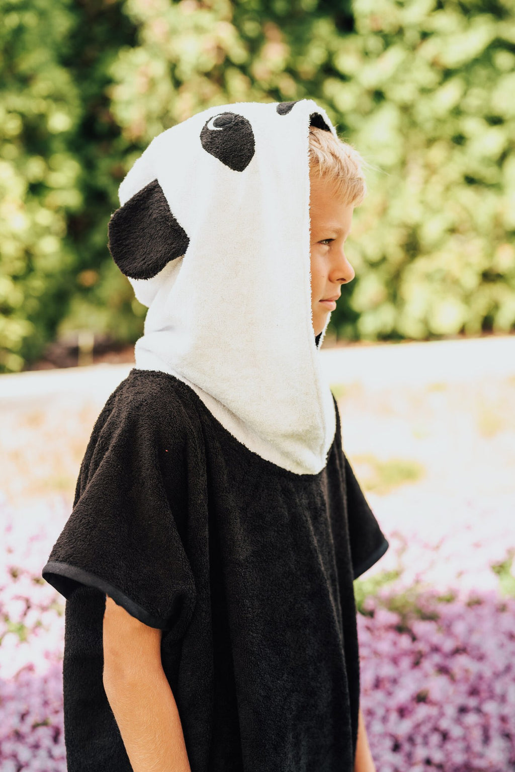 4. Side view of child wearing RÄTT Short-Sleeve Poncho PANDA, highlighting panda hood